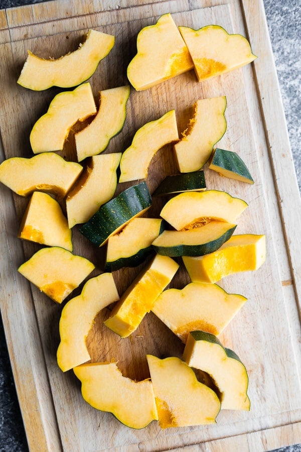 showing how to cut acorn squash on cutting board