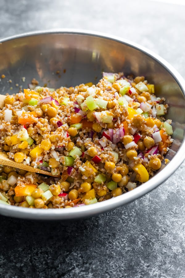 mediterranean chickpea salad in silver bowl after tossing it up