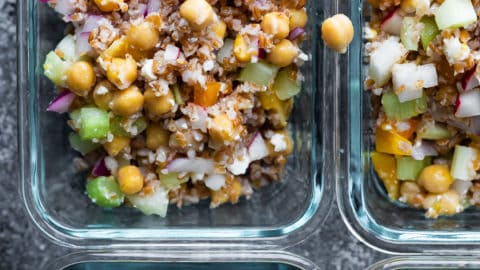 overhead shot of four glass meal prep container with chopped chickpea salad