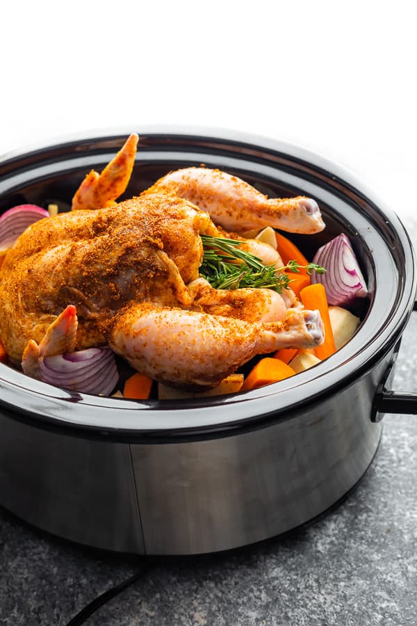 crockpot whole chicken and potatoes in slow cooker before cooking