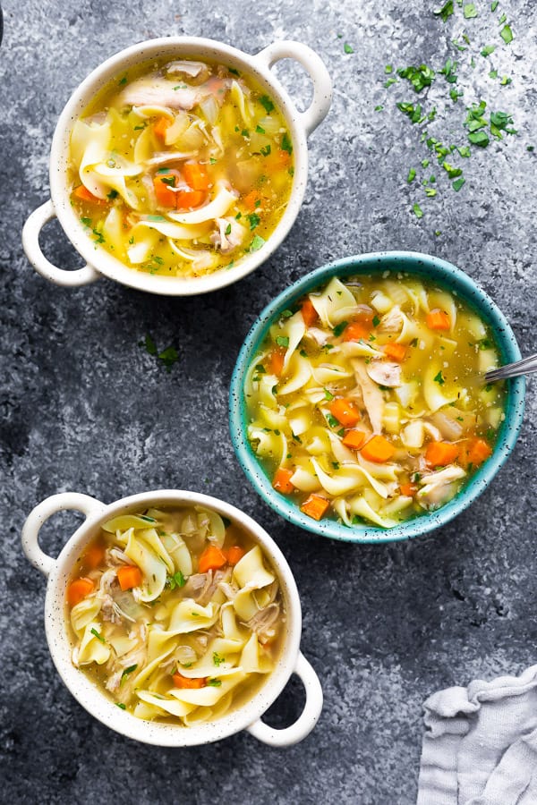 overhead view of three bowls of crockpot chicken noodle soup