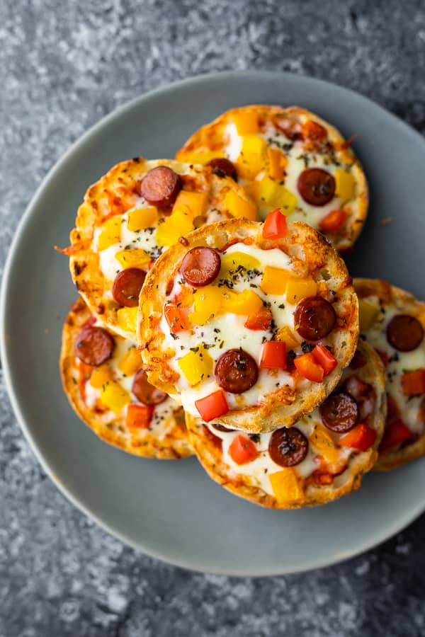 stack of mini pizzas on english muffins on grey plate