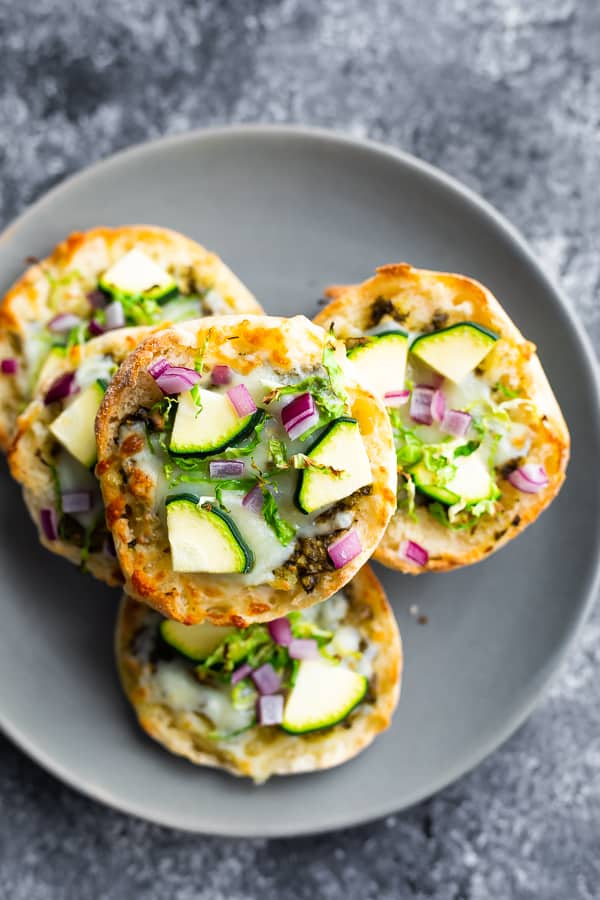 stack of green goddess english muffin pizza on grey plate