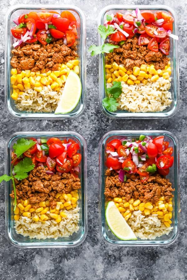 overhead shot of four containers filled with turkey taco meal prep bowls