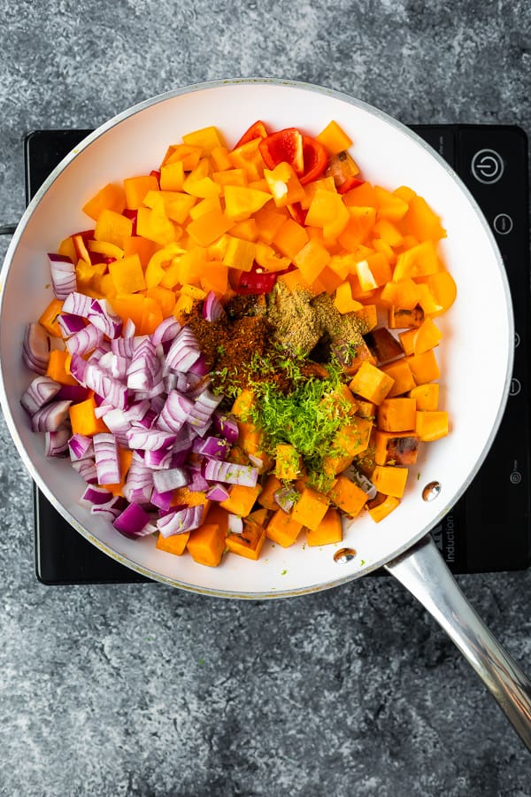 frying pan full of ingredients to cook the one pan chicken and sweet potatoes (before cooking)