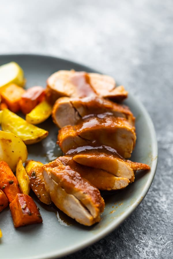 pork tenderloin with apples on plate with glaze drizzled over top