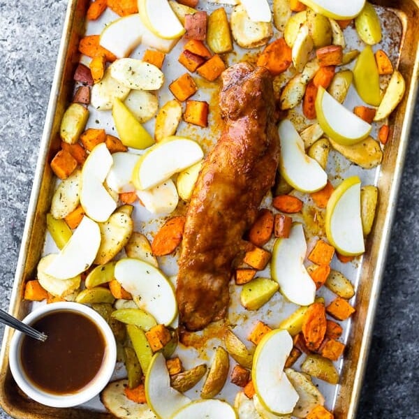 overhead shot of a sheet pan with roasted pork tenderloin and roasted apples and root vegetables