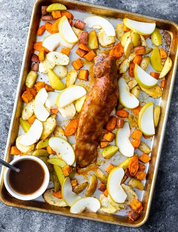overhead shot of a sheet pan with roasted pork tenderloin and roasted apples and root vegetables