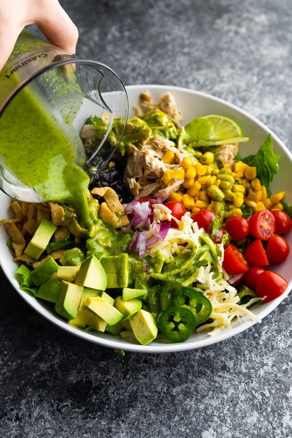 pouring cilantro vinaigrette over beer chicken taco salad