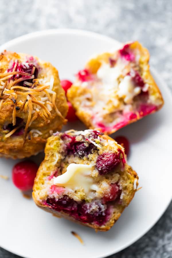 close up shot of cranberry muffins broken in half with butter