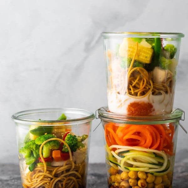 Stack of three jars filled with healthy instant noodles and fresh veggies