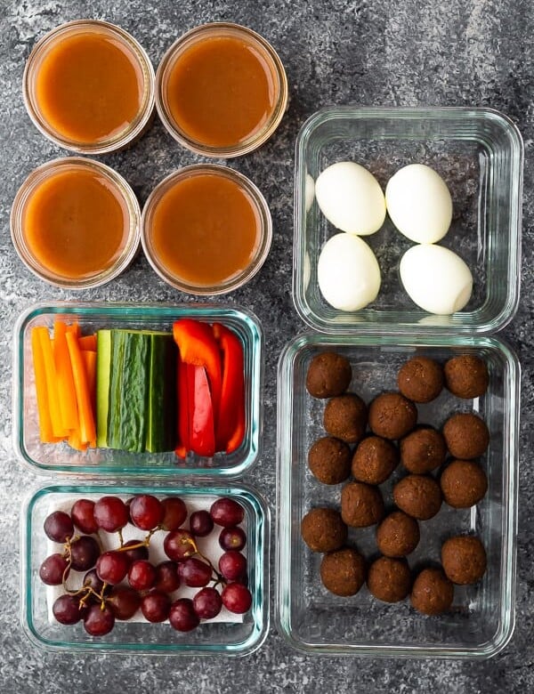 overhead shot of various foods in glass meal prep containers for kids snack drawer ideas