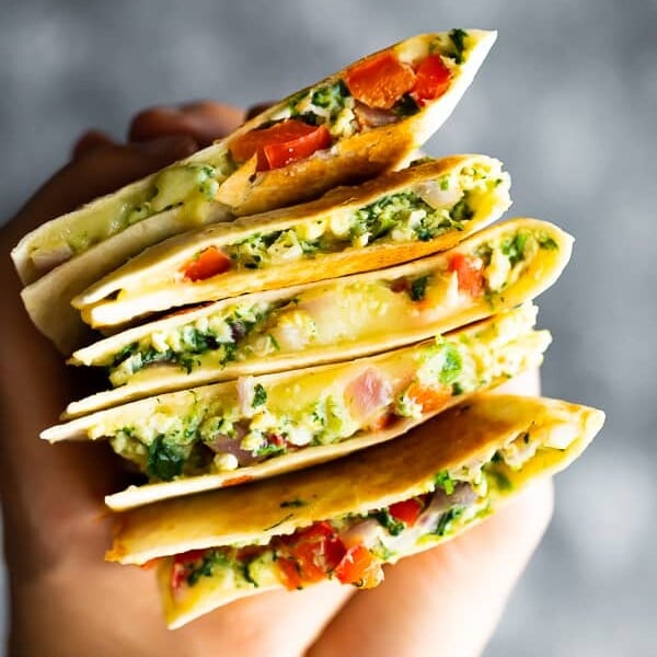hand holding a stack of spinach and feta breakfast quesadilla slices