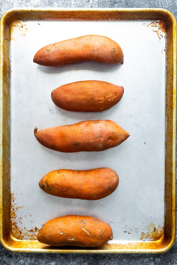 sweet potatoes on baking sheet for stuffed sweet potato recipe