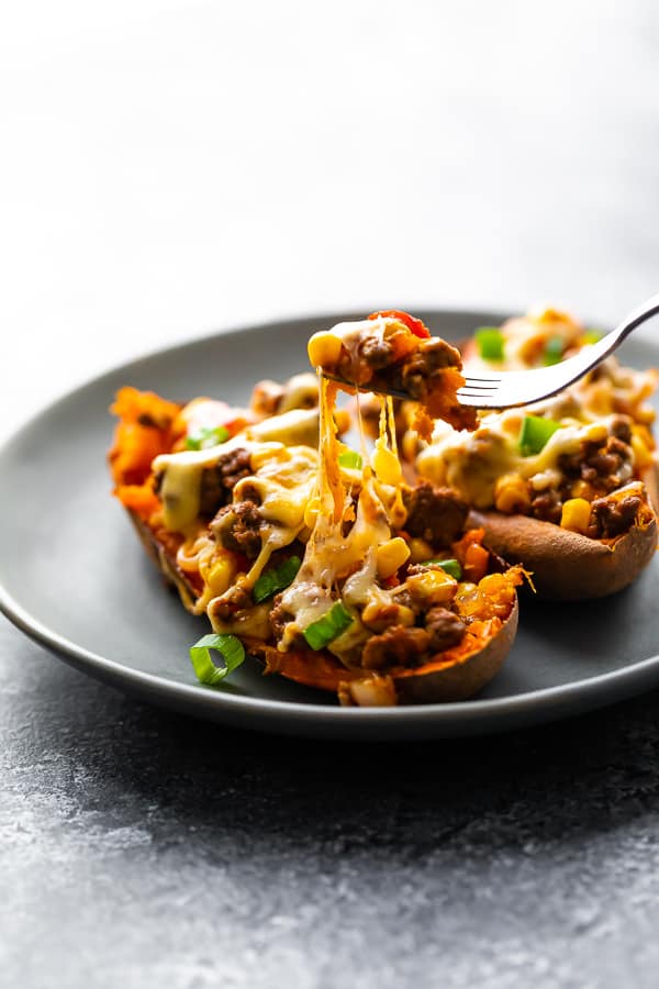 fork pulling cheese up on stuffed sweet potatoes