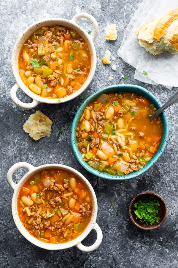 overhead view of three bowls of Sausage and White Bean Soup