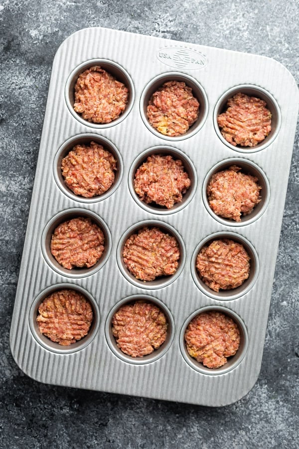 mini muffin tin filled with meatloaf mixture