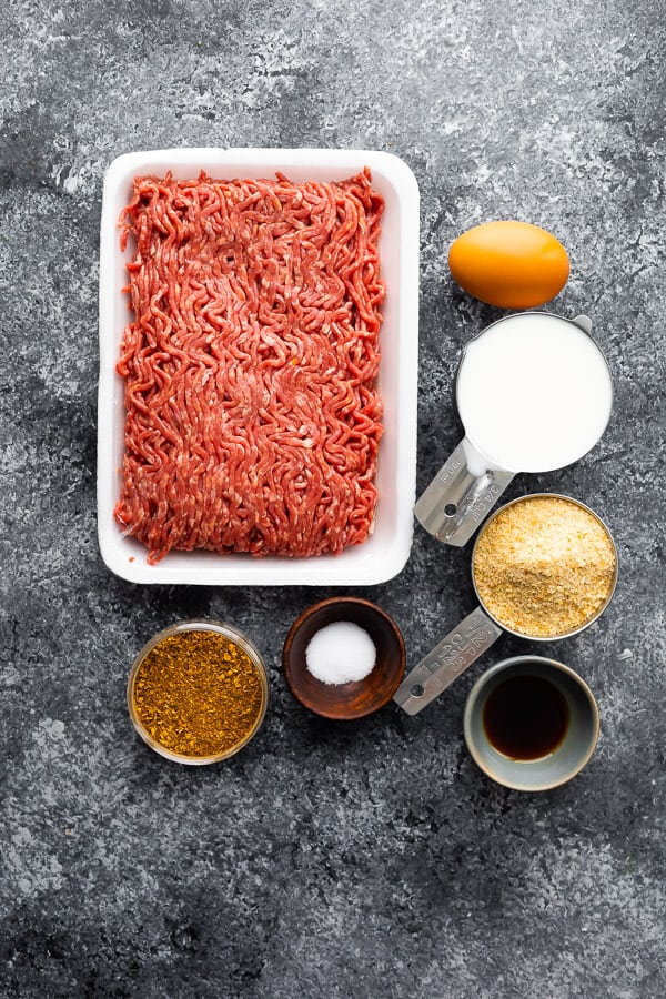 a pound of raw lean ground beef next to Moroccan spices in measuring cups