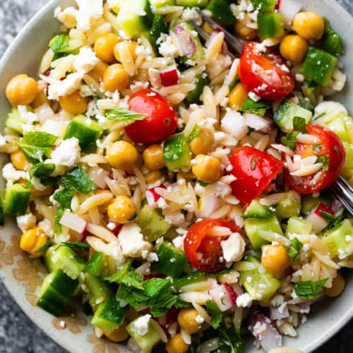 Orzo pasta salad with mint and feta in white bowl