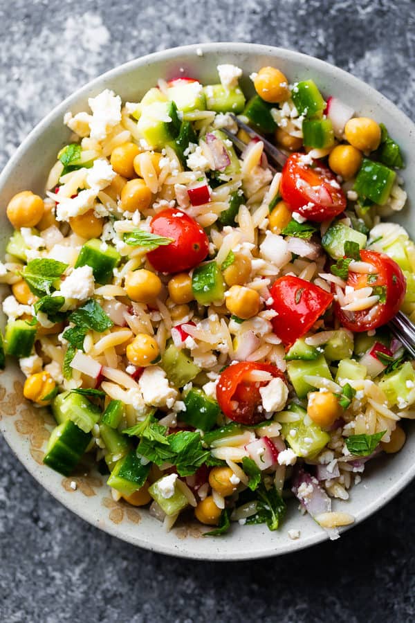 Orzo pasta salad with mint and feta in white bowl