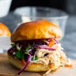 A close up of honey lime shredded chicken sandwich on a wood cutting board