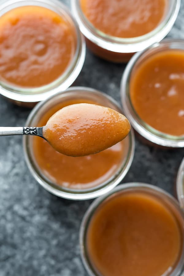 instant pot applesauce on spoon over jars of applesauce