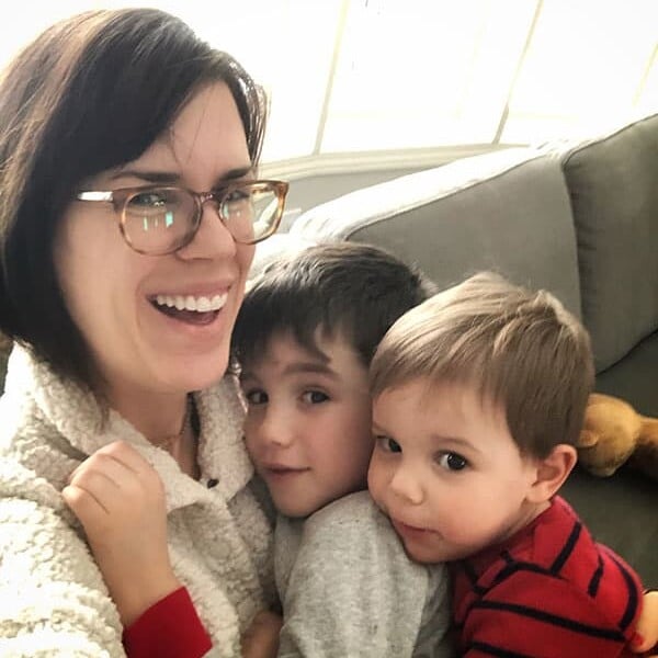 Denise holding her two sons on the couch
