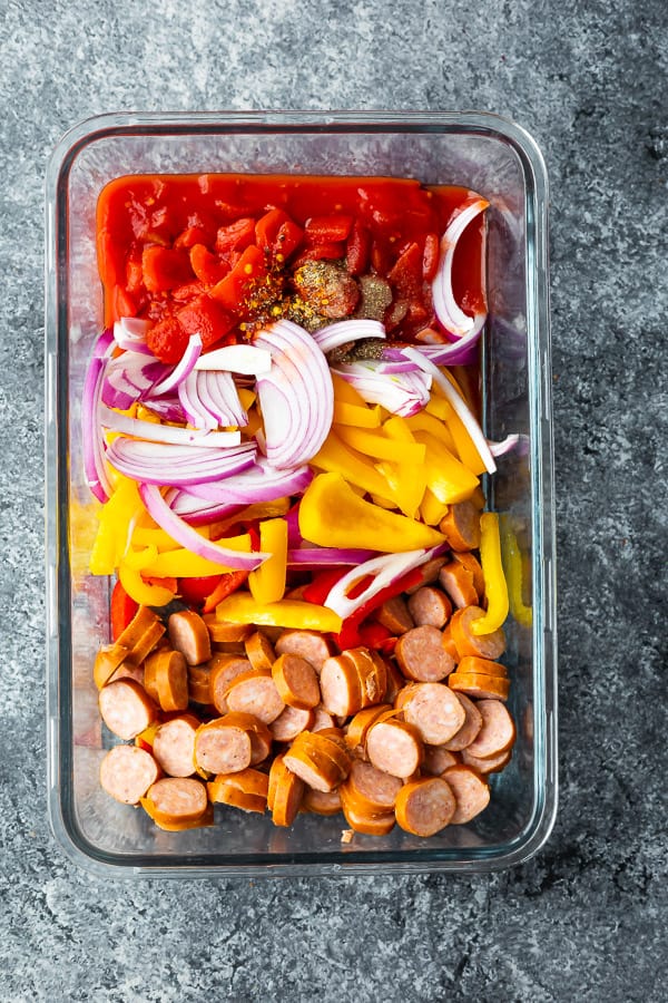 ingredients for one pot sausage pasta in a glass meal prep container