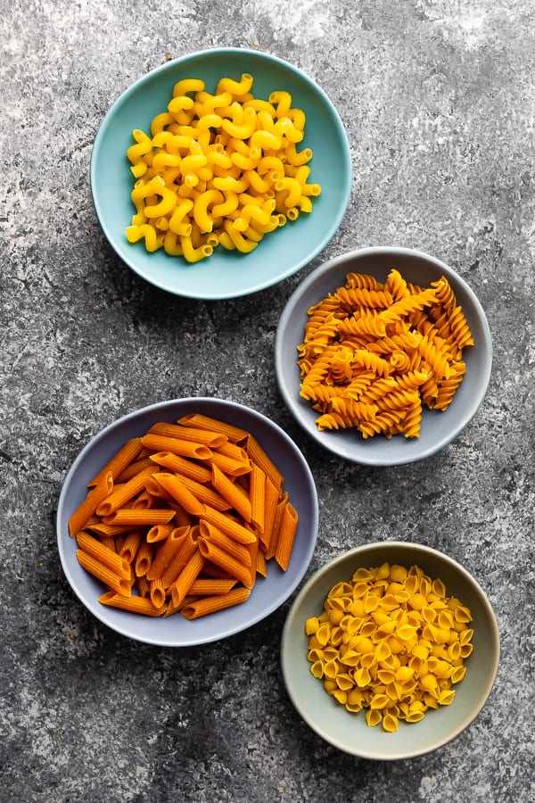 four bowls of different pasta shapes