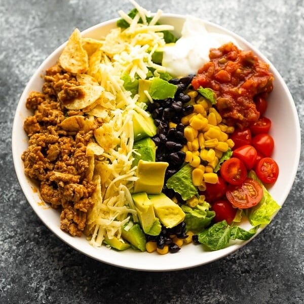 Healthy taco salad in a large white bowl on gray background
