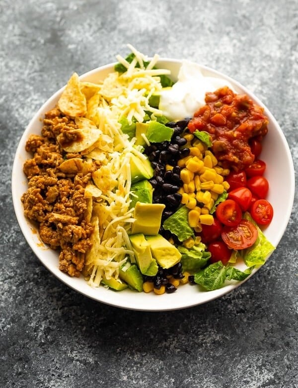 Healthy taco salad in a large white bowl on gray background