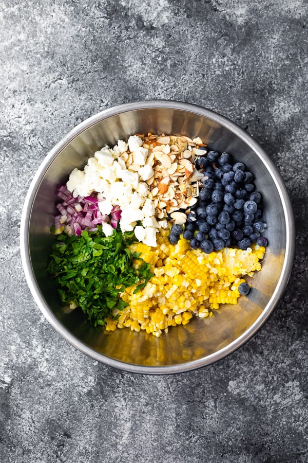 bowl with barley corn salad ingredients before tossing in vinaigrette