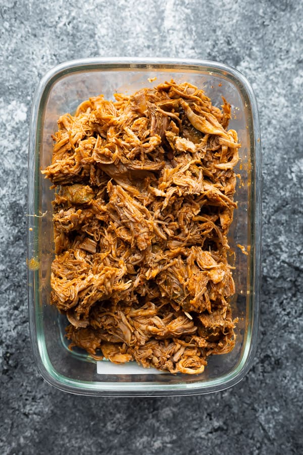 crock pot pulled pork in a large glass meal prep container for storage