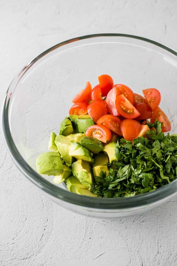 ingredients for avocado salsa in a glass bowl