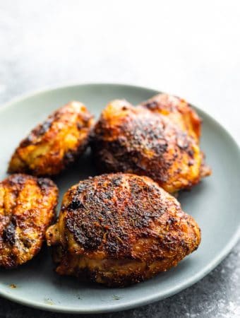 Four chicken thighs on a gray plate