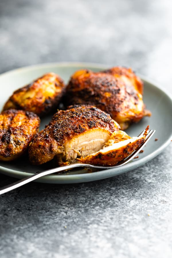 air fryer chicken thigh on plate cut open with piece on fork