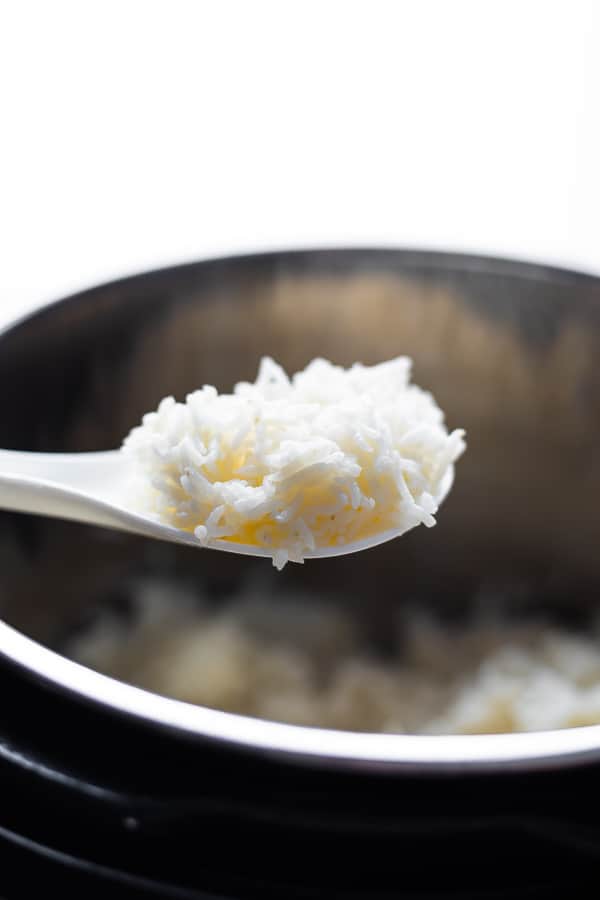 spoon holding basmati rice over the instant pot