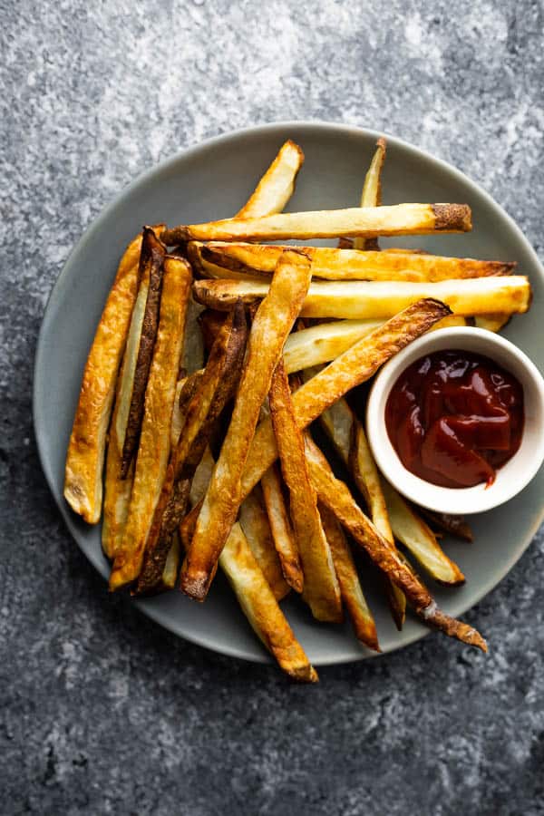 overhead view of air fryer french fries on a plate with ketchup