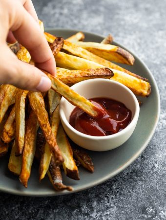 dipping an air fryer french fry into ketchup