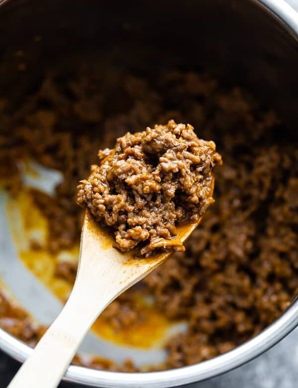 Close up shot of instant pot taco meat on a wooden spoon