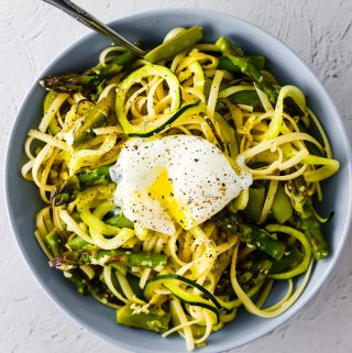 overhead view of spiralized pasta with egg in bowl