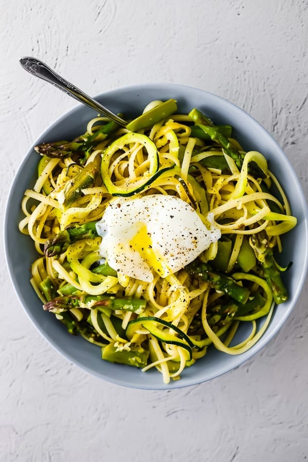 overhead view of spiralized pasta with egg in bowl