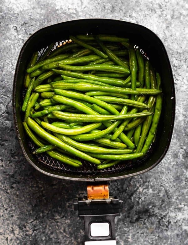 overhead view of green beans in air fryer after cooking through