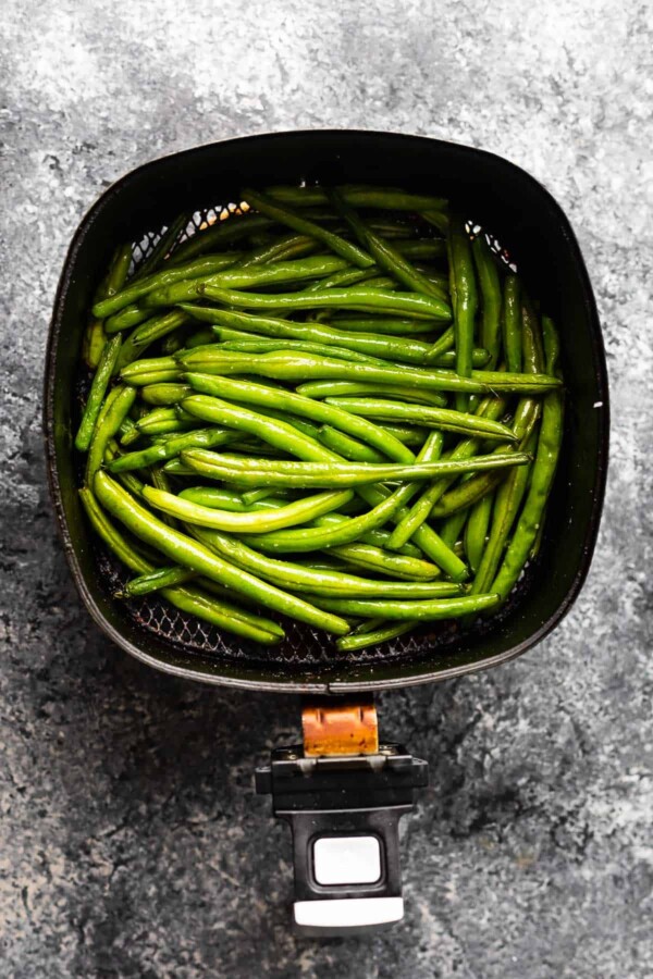 overhead view of green beans in air fryer after cooking through