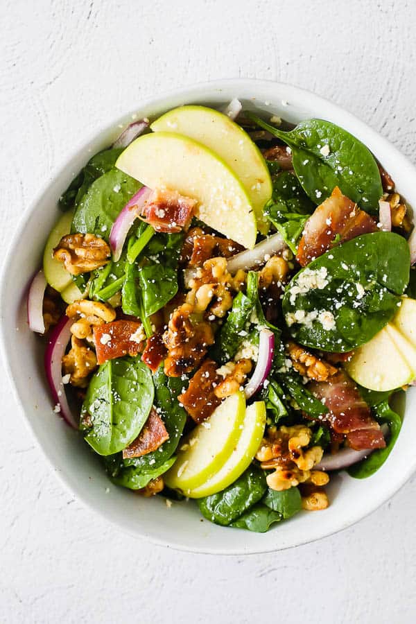 bowl with apple bacon spinach salad mixed up