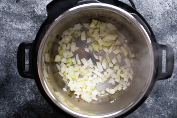 overhead view of onions sauteeing in an instant pot