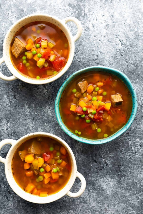 overhead view of three bowls of vegetable beef soup