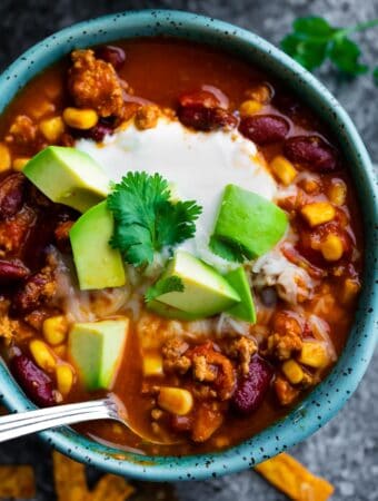 instant pot turkey chili in a bowl with toppings and spoon
