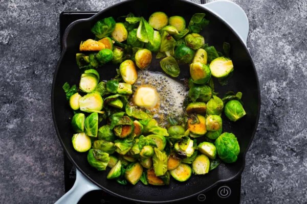 cooked brussels sprouts in skillet with butter melting in the middle