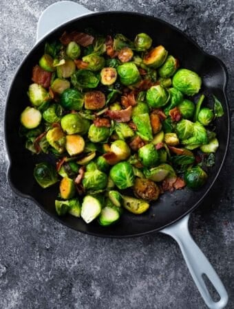 overhead view of brussels sprouts with bacon in a skillet